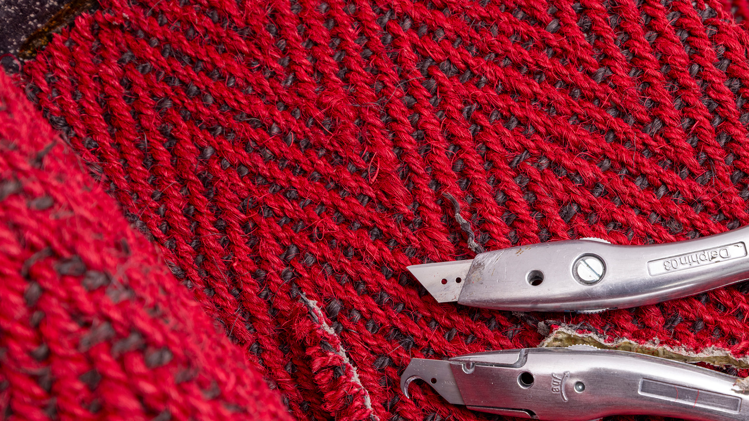 zwei Teppichmesser die auf einem Teppich liegen